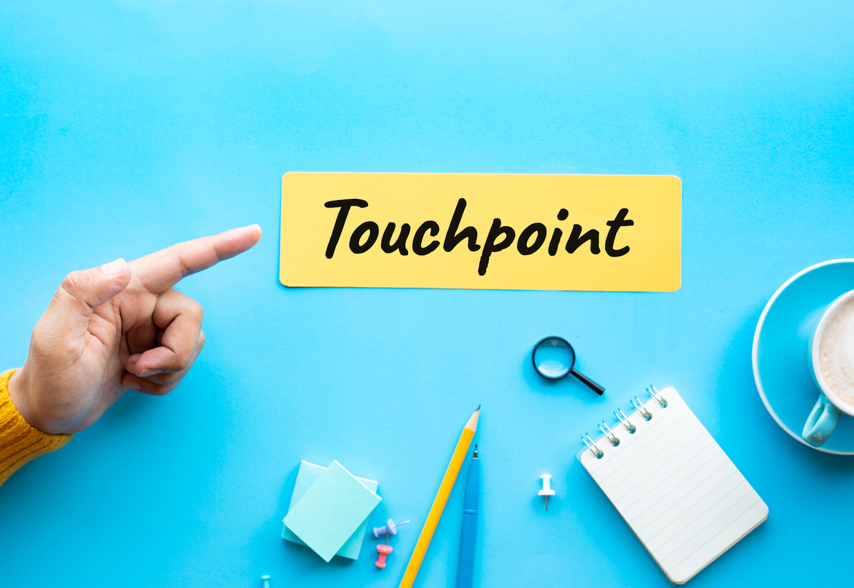 hand pointing to yellow note that reads "Touchpoint"