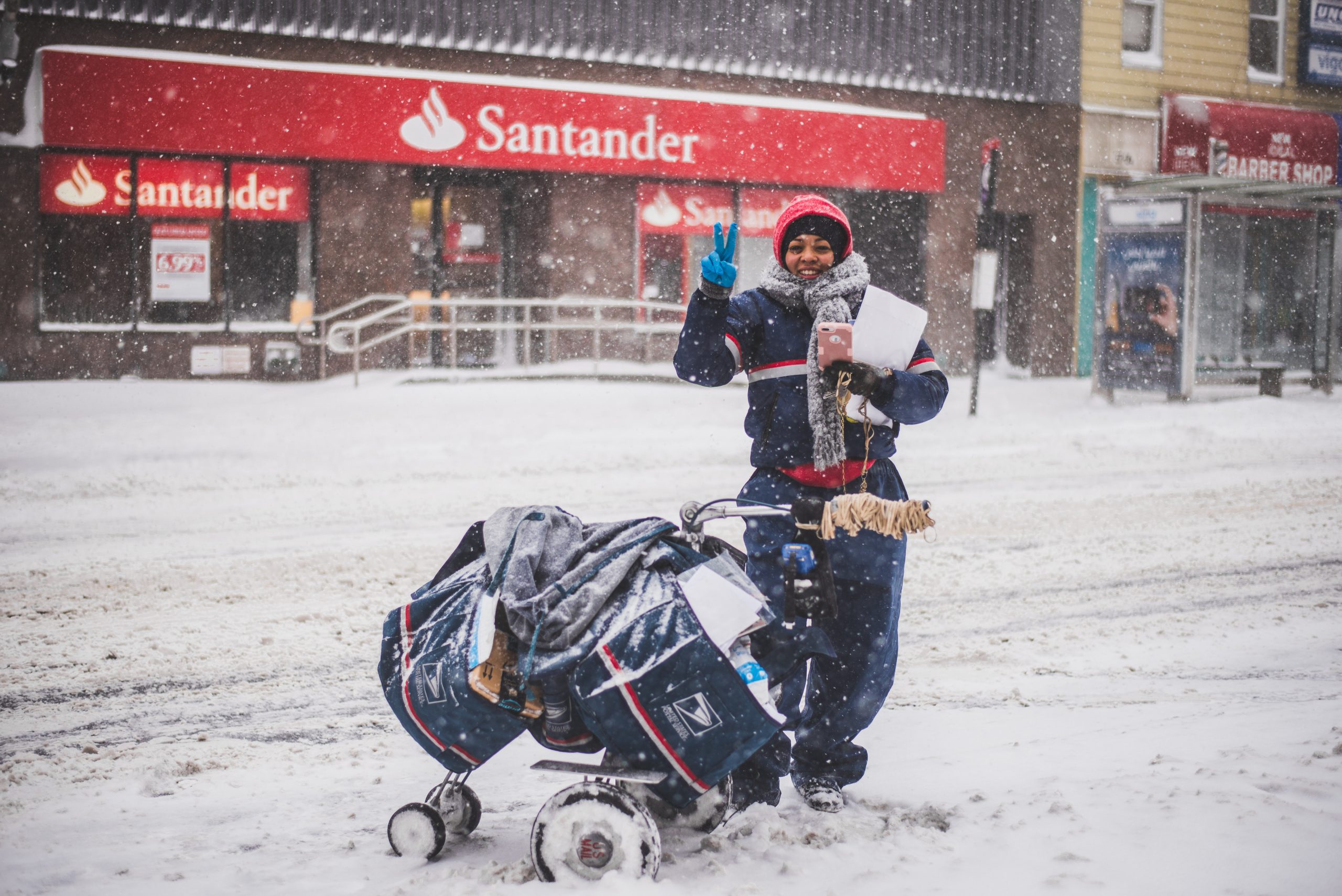 Employee of the post office delivering direct mail marketing pieces in the snow